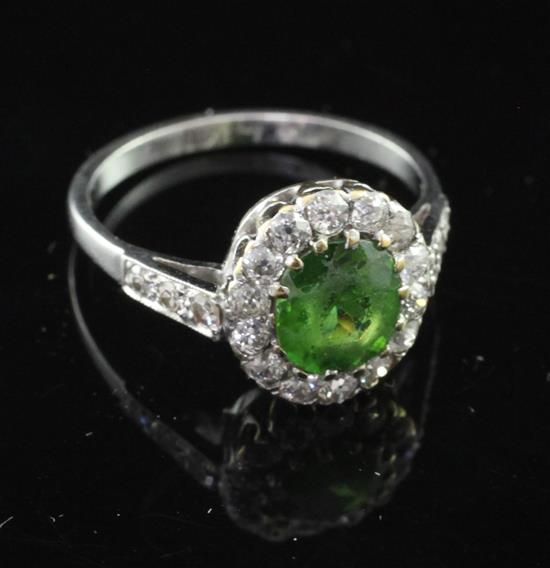 An early 20th century platinum demantoid garnet and diamond cluster ring, size K.